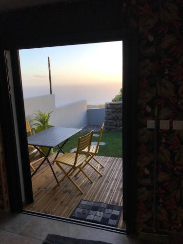Elle offre une vue sur une terrasse avec une table et des chaises. dans l'établissement loft meublé fonctionnel proche de grande anse, à Petite Île