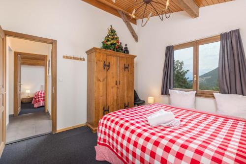 ein Schlafzimmer mit einem roten und weißen karierten Bett in der Unterkunft Chalet Nicolas in Riddes