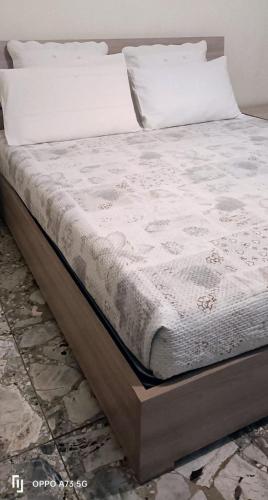 ein Bett mit weißer Bettwäsche und Kissen darauf in der Unterkunft B&B LEO'S in Cagliari