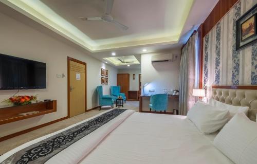 um quarto de hotel com uma cama e uma televisão em Hotel Emirates em Calcutá