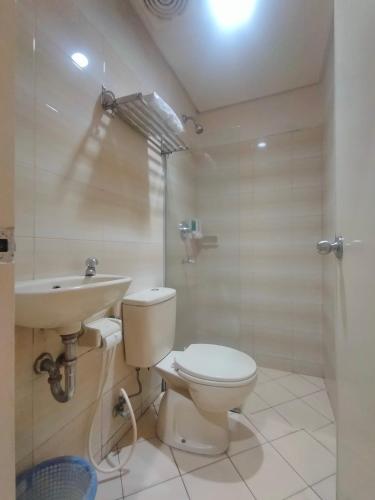 ein Bad mit einem WC, einem Waschbecken und einer Dusche in der Unterkunft The Abidin Hotel Syari'ah in Padang
