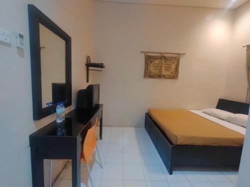 um quarto com uma cama e uma cómoda com um espelho em The Abidin Hotel Syari'ah em Padang