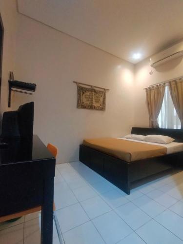 um quarto com uma cama e uma televisão em The Abidin Hotel Syari'ah em Padang