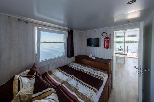 a bedroom with two beds and a window at feststehendes Hausboot in Kolonie Zern