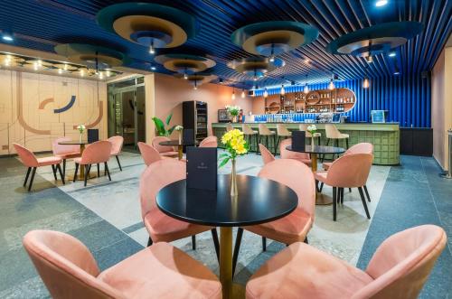 a restaurant with pink chairs and a table and a bar at Hunguest Bük - ex Répce és Répce Gold in Bük