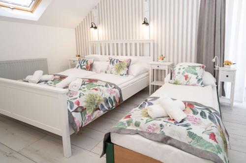 1 dormitorio con 2 camas y 2 sillas en Villa Rose Garden en Nyíregyháza