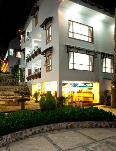 a large white building with windows at night at Melody Hotel in Da Lat