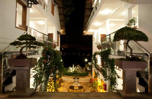 a balcony with two bonsai trees on the side of a building at Melody Hotel in Da Lat