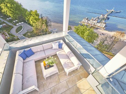 una vista dall'alto di un balcone con divano e sedie di "FIRST" Sellin Penthouse "Meerblick & SPA" a Ostseebad Sellin