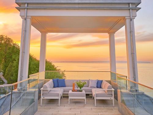 un gazebo con un divano e sedie su un balcone di "FIRST" Sellin Penthouse "Meerblick & SPA" a Ostseebad Sellin