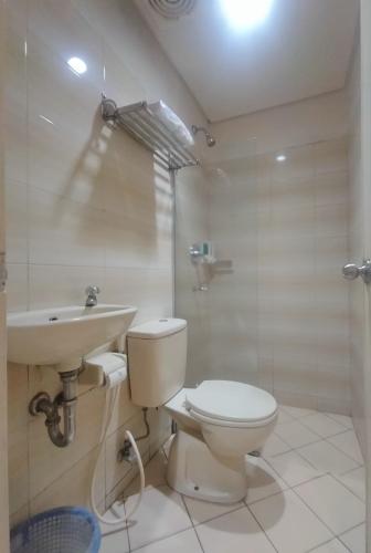 a bathroom with a toilet and a sink and a shower at The Abidin Hotel Syari'ah in Padang