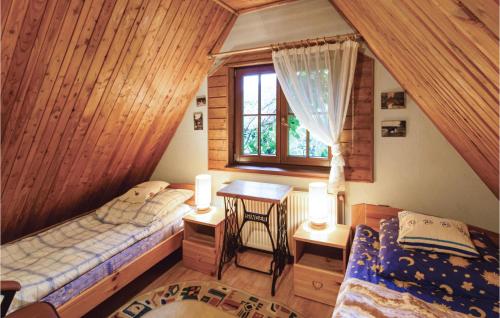 a attic bedroom with two beds and a window at Gorgeous Home In Milakowo With Wifi in Morąg