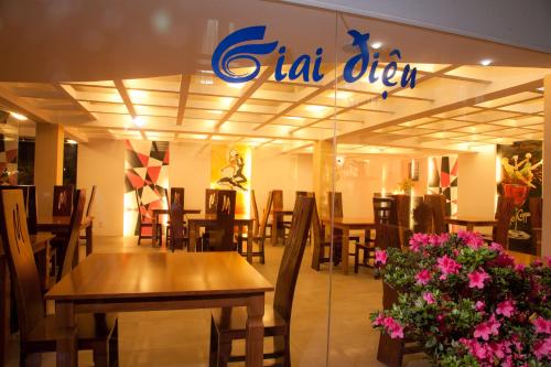 a restaurant with tables and chairs and a sign on the wall at Melody Hotel in Da Lat
