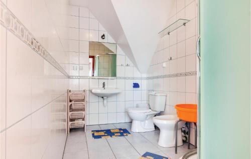 a white bathroom with a toilet and a sink at Cozy Apartment In Rowy With Kitchen in Rowy