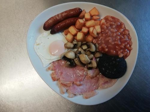 a plate of breakfast food with eggs beans and mushrooms at The Antelope Hotel in Merthyr Tydfil