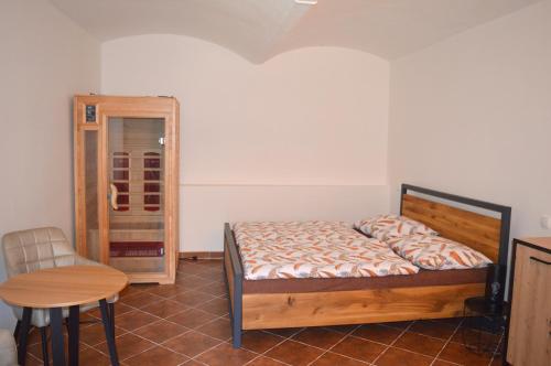 um quarto com uma cama, uma mesa e uma cadeira em Vincentův dvůr 