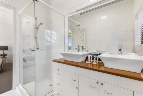 a bathroom with two sinks and a shower at Commodore 7 80 Noosa Parade in Noosa Heads