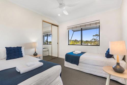 a bedroom with two beds and a window at Commodore 7 80 Noosa Parade in Noosa Heads