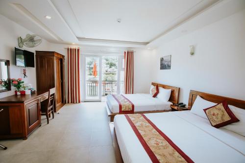 Pokój hotelowy z 2 łóżkami i biurkiem w obiekcie Lien Huong Hotel w mieście Da Lat