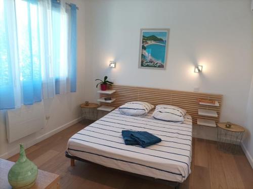ein Schlafzimmer mit einem Bett mit zwei Kissen darauf in der Unterkunft Lou Farniente - Les Lecques - Fabuleux in Saint-Cyr-sur-Mer