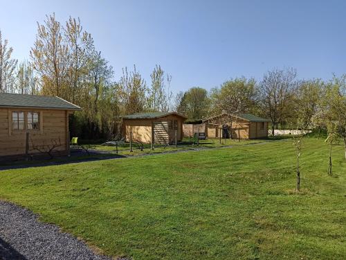 a group of huts in a field with a yard at Verton, Gîte Les chalets du Fliers Meublés de tourisme classés 2 étoiles plage de BERCK SUR MER in Verton