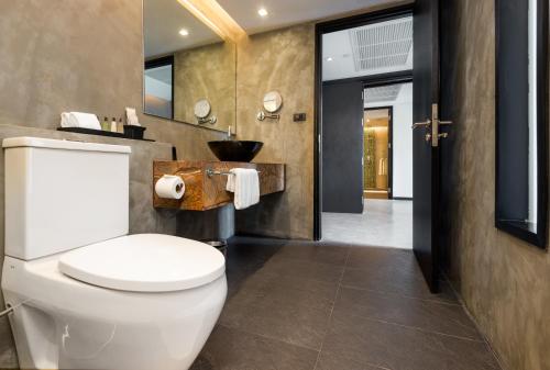 a bathroom with a toilet and a sink at Maitria Mode Sukhumvit 15 Bangkok - A Chatrium Collection in Bangkok