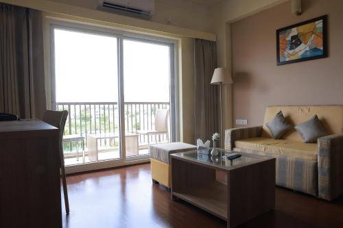 a living room with a bed and a couch and a table at Starlit Suites Tirupati in Tirupati