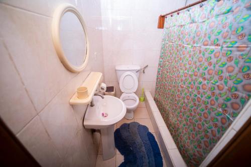 y baño con aseo, lavabo y ducha. en Bombay Hotel, en Accra