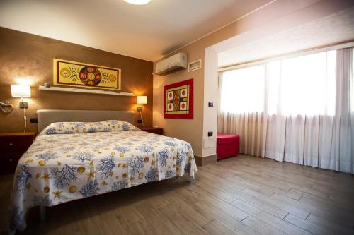 um quarto com uma cama e uma grande janela em Attico Sul Mare In Centro em Capo dʼOrlando