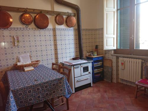 una cucina con tavolo e pentole e padelle sul muro di Casa Vacanze Piazza Apartment 2 a SantʼAndrea di Conza