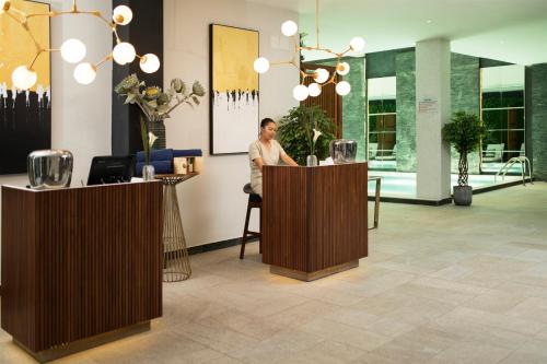 a man sitting at a counter in a lobby at Le Centell Hotel & Spa in Antananarivo