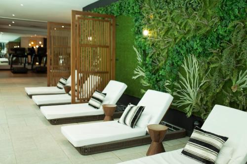 a row of white chairs in a room with plants at Le Centell Hotel & Spa in Antananarivo
