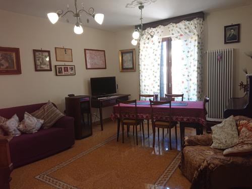 un soggiorno con divano e tavolo da pranzo di Casa Vacanze Piazza Apartment 2 a SantʼAndrea di Conza