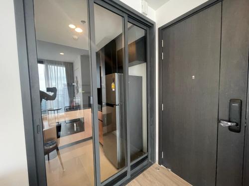 a sliding glass door leading into a kitchen with a refrigerator at The Edge central pattaya in Pattaya Central