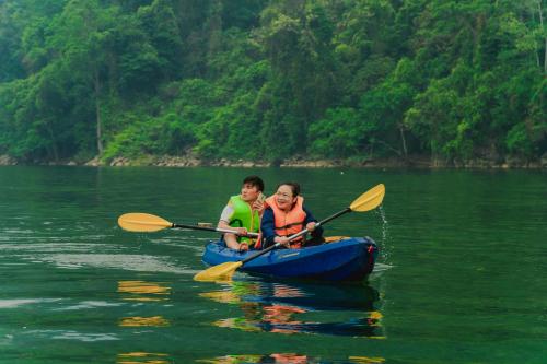 two people in a blue kayak on the water at Ba Bể Green (View Ba Be lake) in Bak Kan