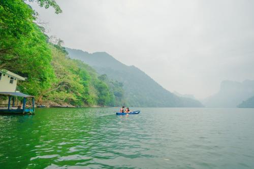 two people are in a boat on a river at Ba Bể Green (View Ba Be lake) in Bak Kan