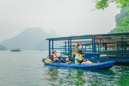 two people on a boat in the water at Ba Bể Green (View Ba Be lake) in Bak Kan