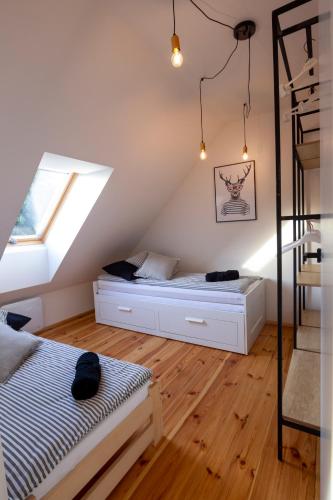 a attic bedroom with two beds and a ladder at Siedlisko Pozorty in Pozorty