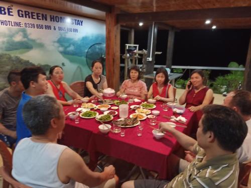 a group of people sitting around a table eating food at Ba Bể Green (View Ba Be lake) in Bak Kan