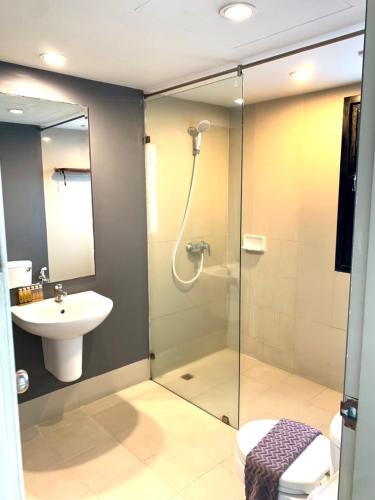 a bathroom with a shower and a toilet and a sink at ABIZZ Hotel Lampang Airport in Lampang