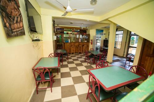 un restaurante con mesas y sillas y suelo a cuadros en Bombay Hotel, en Accra