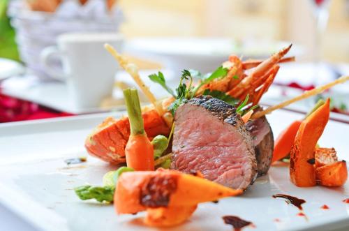 a plate of food with meat and vegetables on it at Wanda Reign Resort & Villas Sanya Haitang Bay in Sanya