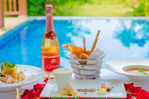 a table with plates of food and a bottle of beer at Wanda Reign Resort & Villas Sanya Haitang Bay in Sanya