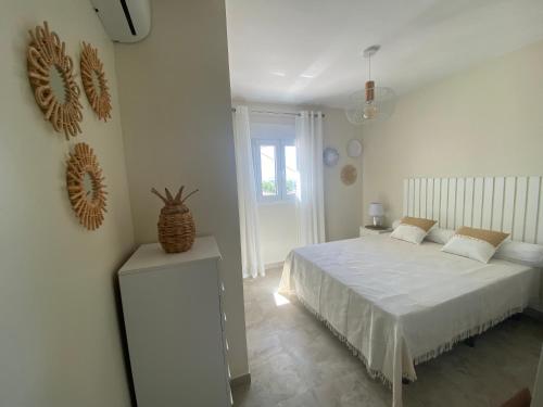 ein weißes Schlafzimmer mit einem Bett und einem Fenster in der Unterkunft Stark - AzulenaCalpe in Calpe