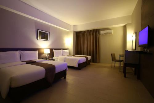 um quarto de hotel com duas camas e uma televisão de ecrã plano em Sequoia Hotel em Manila