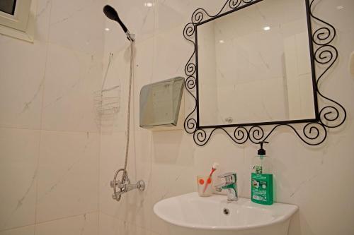 a bathroom with a sink and a mirror at Super OYO 629 Home Lux Suite in Riyadh