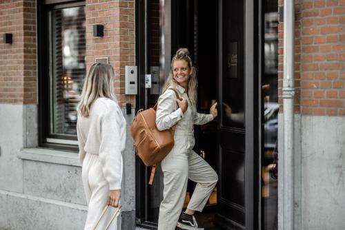 een vrouw stapt uit een gebouw bij Le Petit Marin Boutique Hotel in Rotterdam