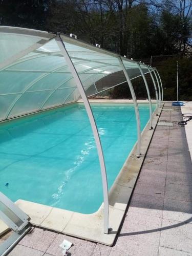 einen Pool mit einer Abdeckung über dem Wasser in der Unterkunft Appartement dans habitation privée avec piscine in La Milesse