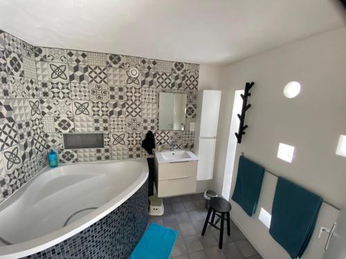 baño con bañera grande y lavamanos en Grand studio de 38m2 et cour indépendante de 25m2 dont wifi et Netflix en Montpellier