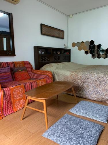 a living room with two beds and a coffee table at Kiang Mo Gumpuju in Chiang Mai